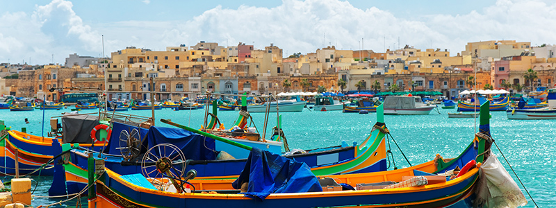 Vackra och färgglada båtar i fiskebyn Marsaxlokk hamn.